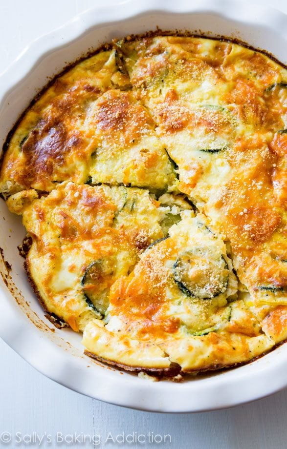 crustless veggie quiche in a white baking dish cut into slices