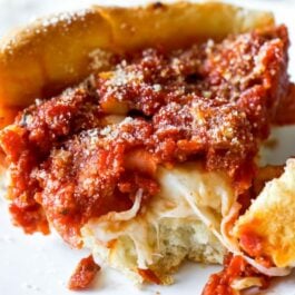 slice of deep dish pizza on a white plate