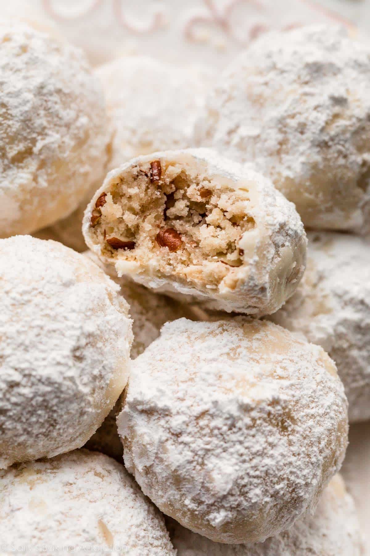 close-up photo of pecan snowball cookie with bite taken out.