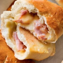 ham and cheese pockets with one pocket cut in half showing ham and cheese filling