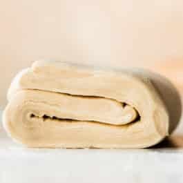 homemade puff pastry dough displaying all the layers of folded dough and butter inside