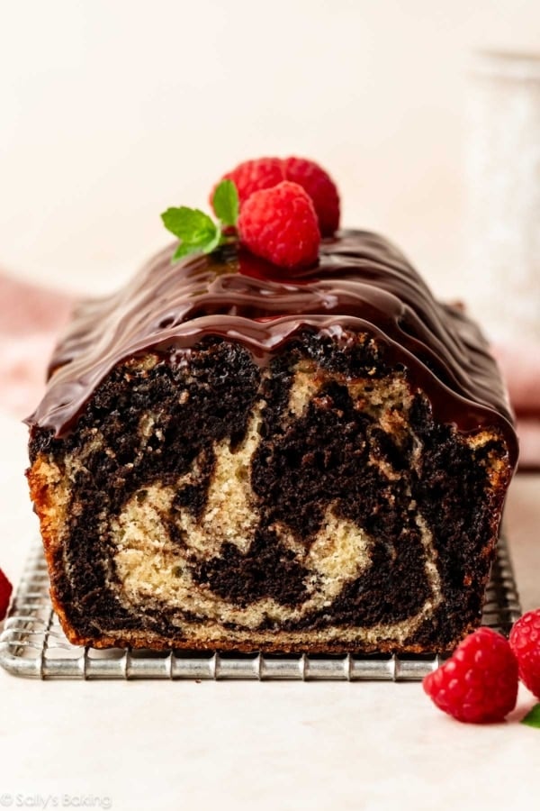 marble loaf cake with ganache and fresh raspberries on top.