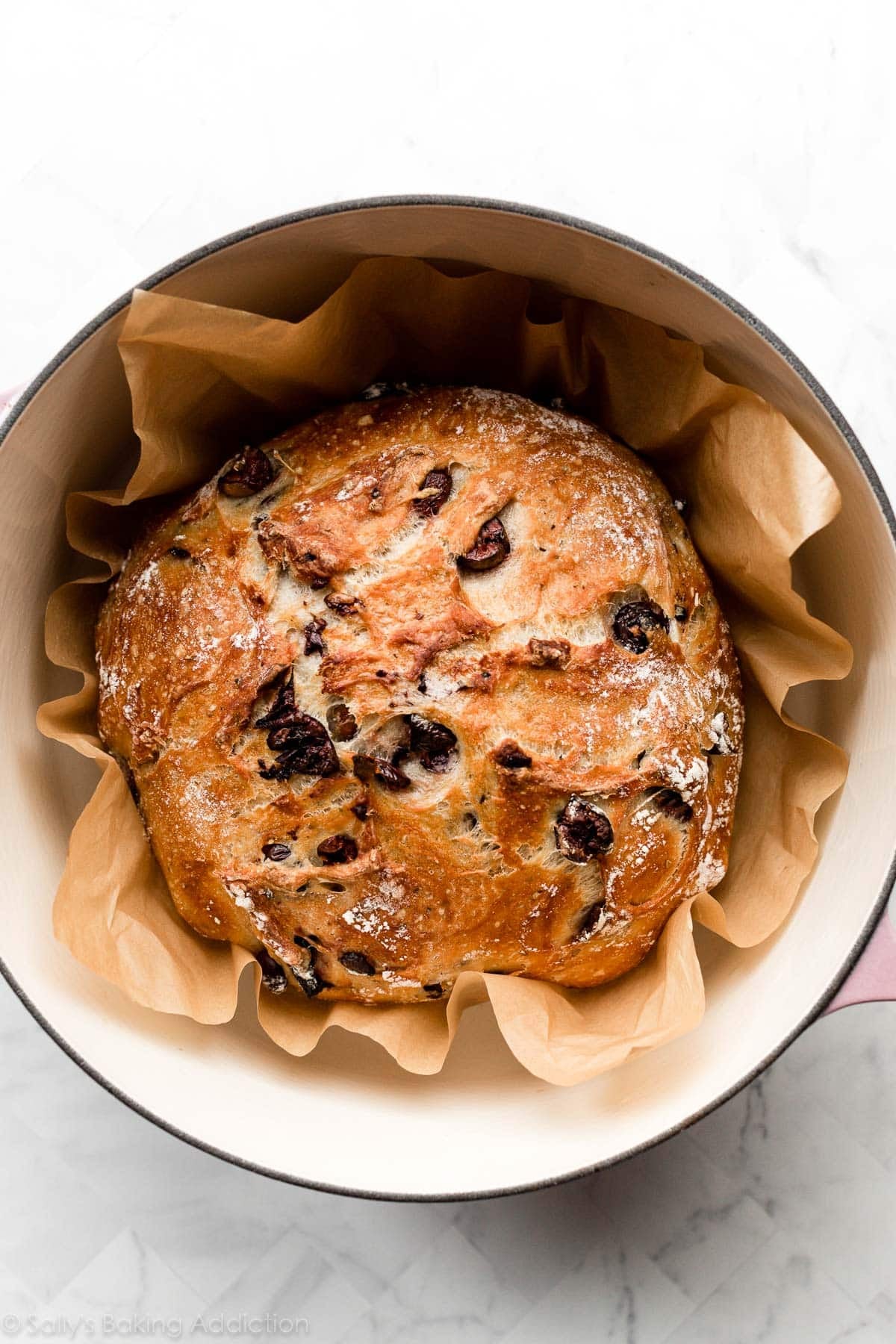 baked olive bread shown in a dutch oven