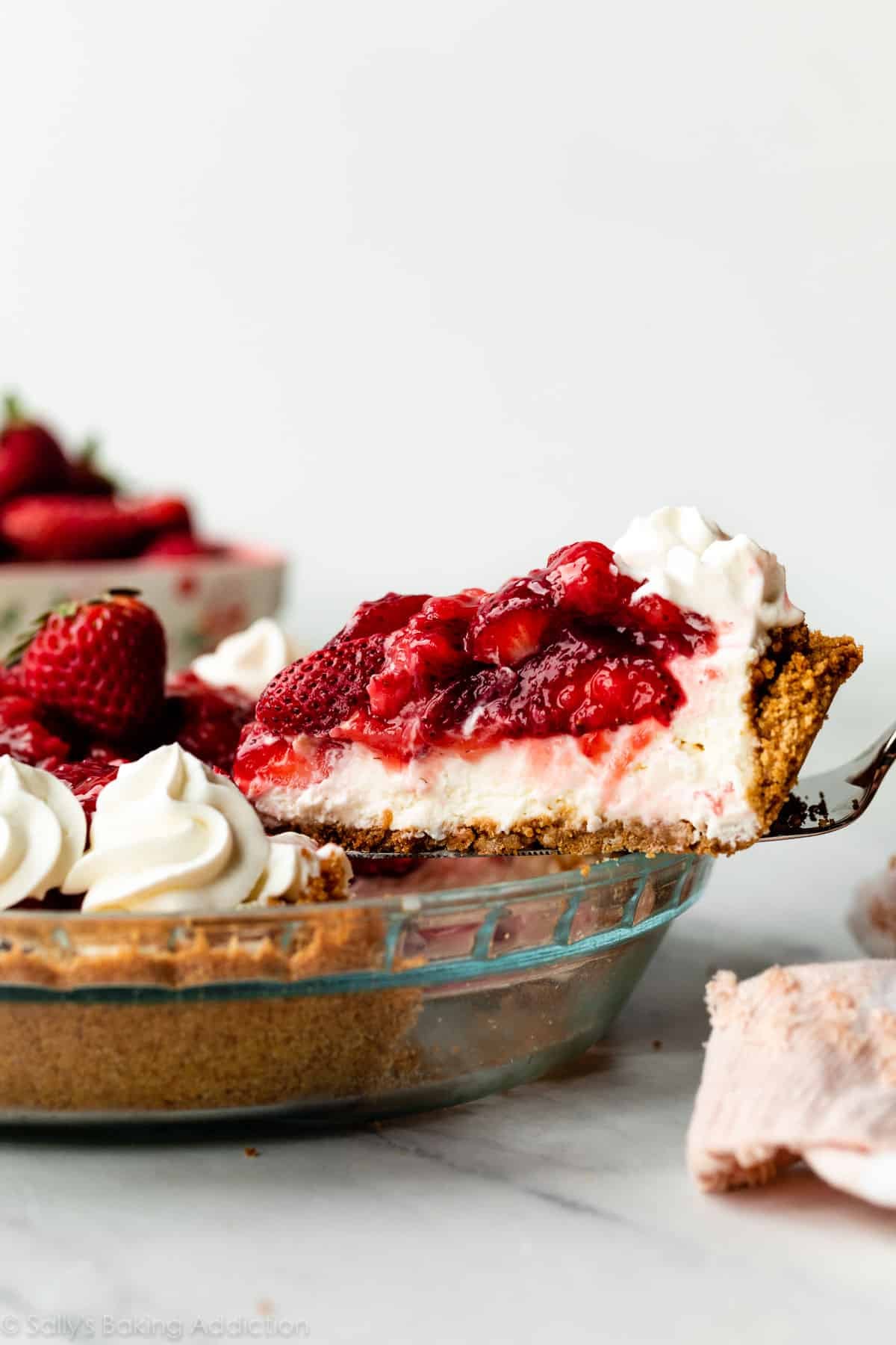 removing slice of strawberry pie from pie dish