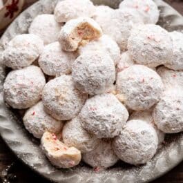 peppermint candy cane snowball cookies in gray dish.