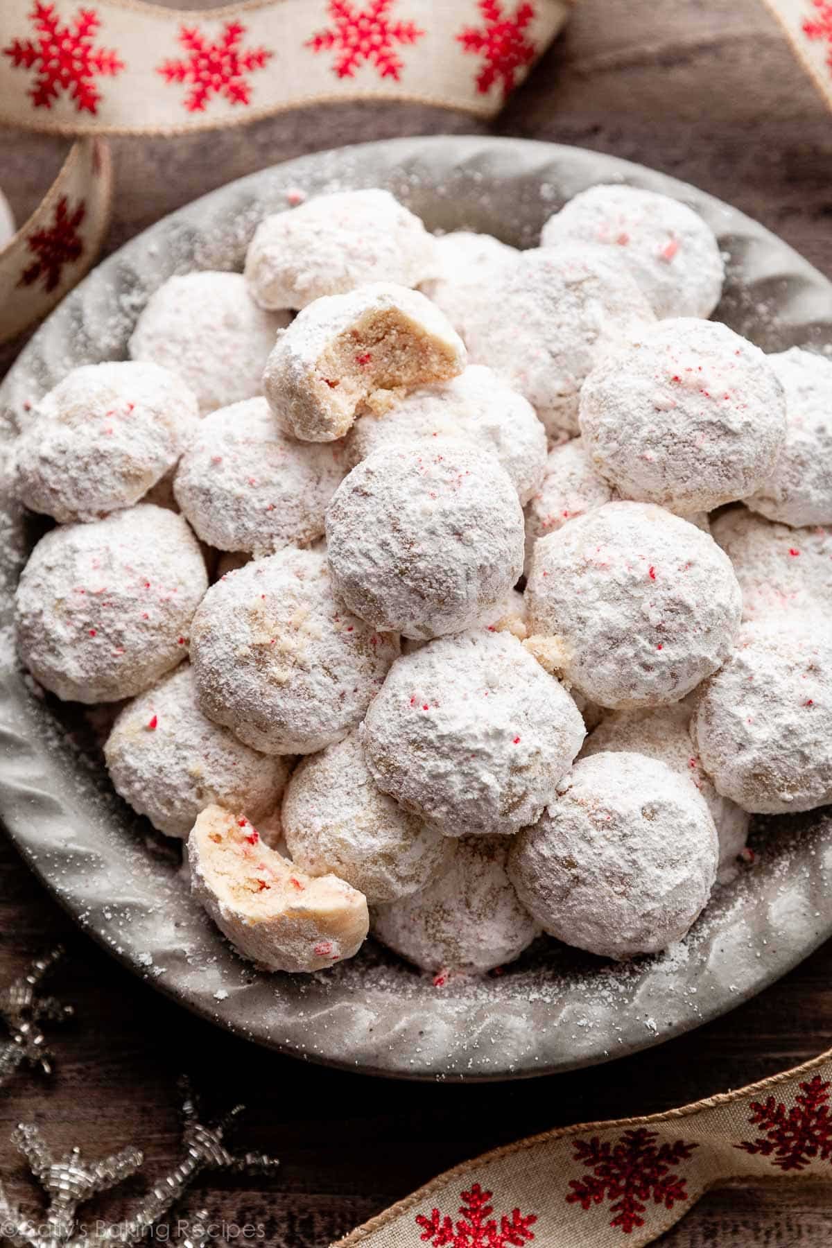 peppermint candy cane snowball cookies in gray dish.