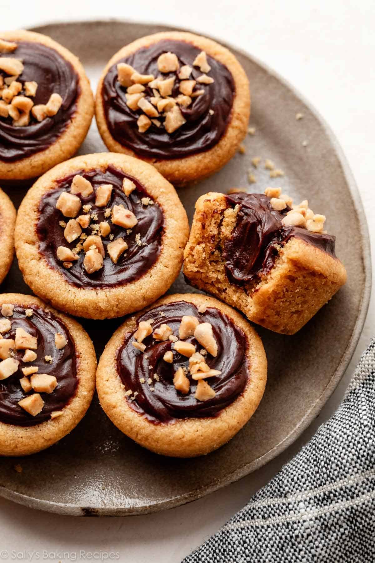peanut butter fudge puddles with 1 bite taken out on gray plate.
